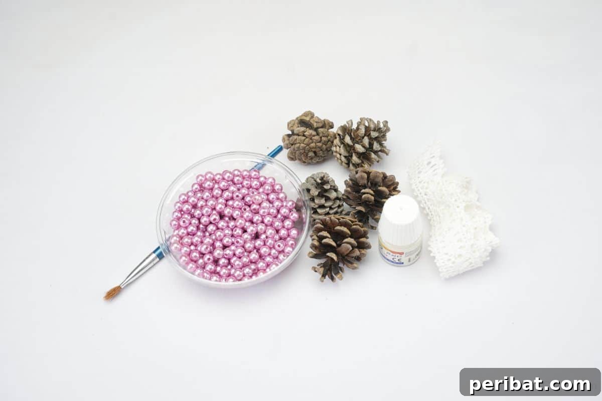 Glistening Bead-Adorned Pinecone Star 7 glass bowl of pink beads on table next to paintbrush and pinecones