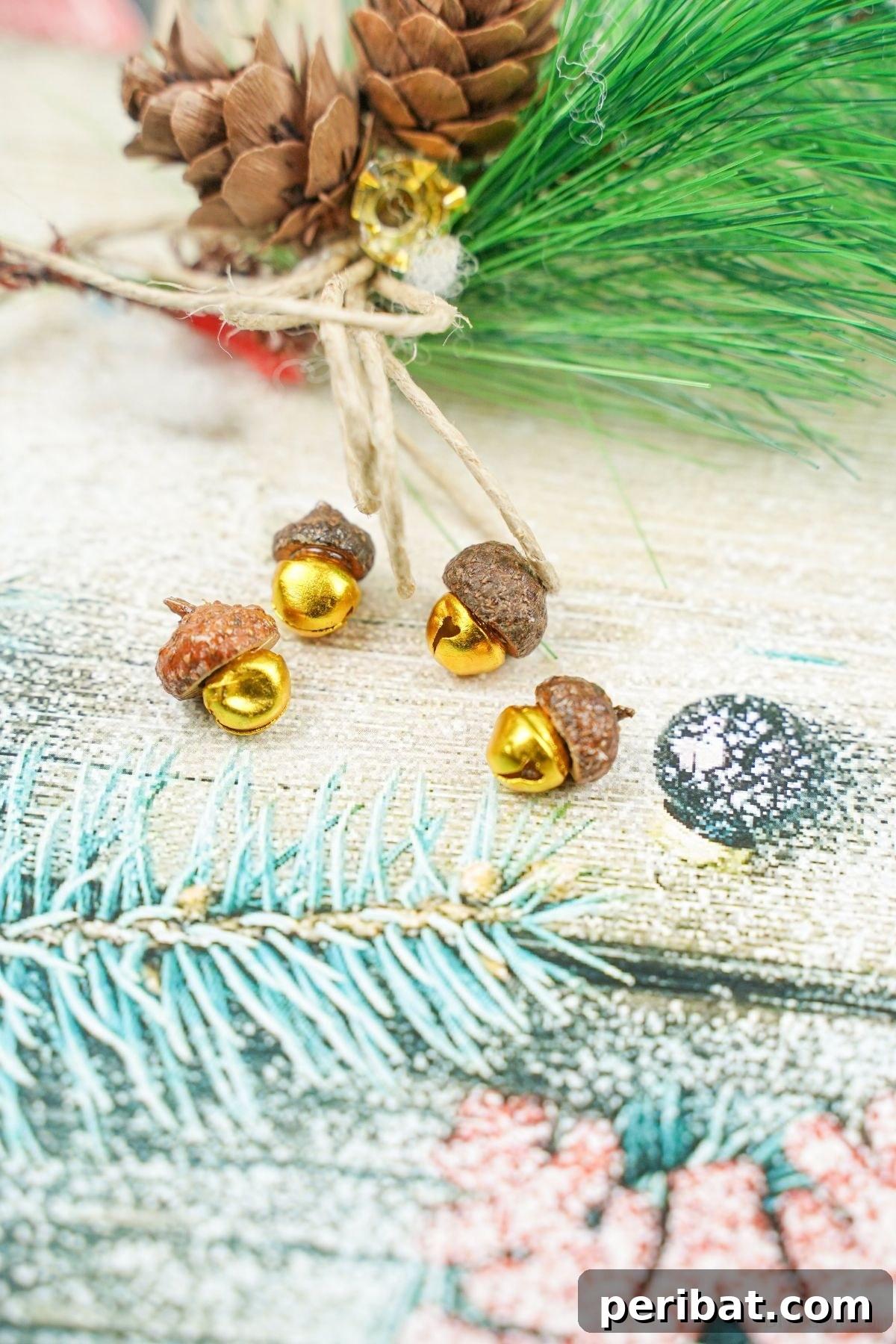 Light blue holiday scrapbook paper with four handcrafted acorn jingle bells on top, featuring golden bells