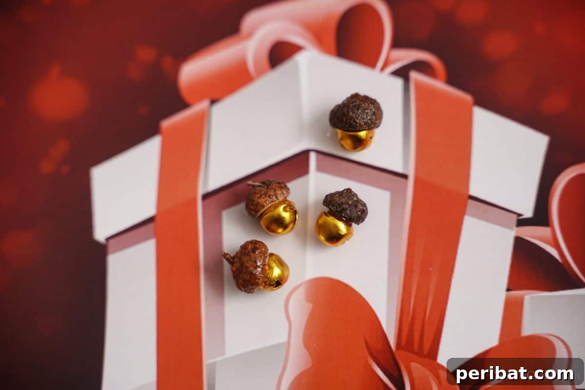 Several acorn cap bells gracefully arranged on a festive holiday paper with a painted white box