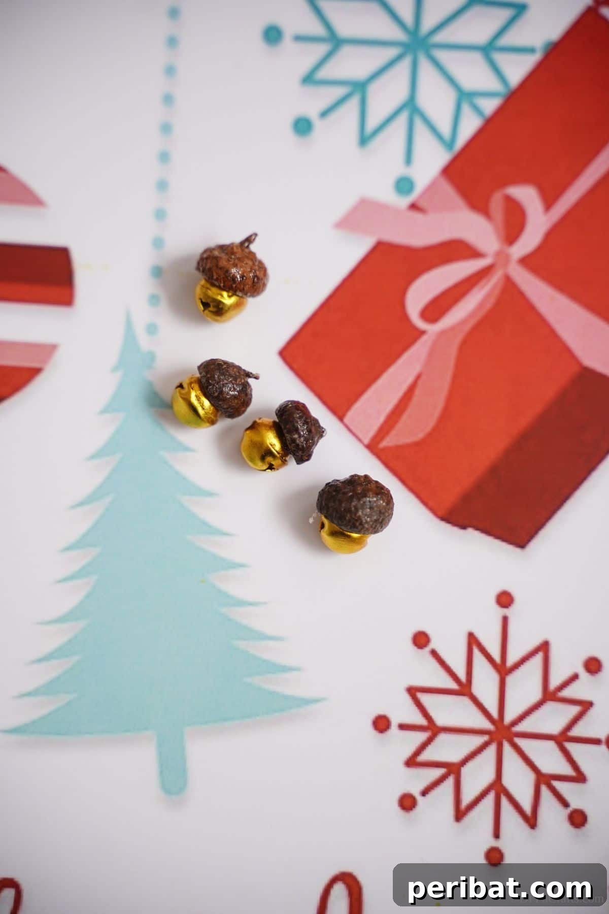 Close-up of golden bells with acorn cap tops, resting on charming holiday-themed paper