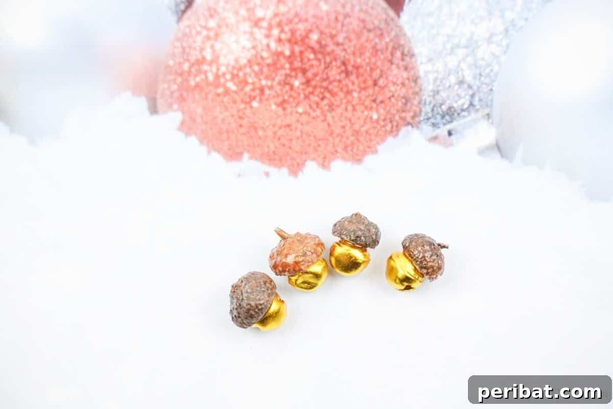 Close-up of elegant acorn cap bells delicately placed on pristine white holiday paper