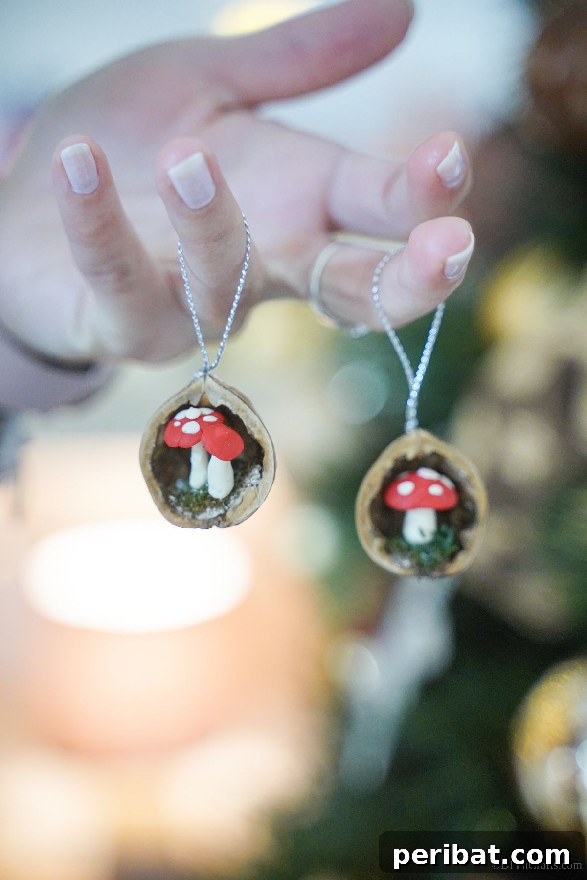 A hand gracefully dangles multiple walnut shell ornaments from its fingers, showcasing the various unique figures nestled within each miniature decoration.