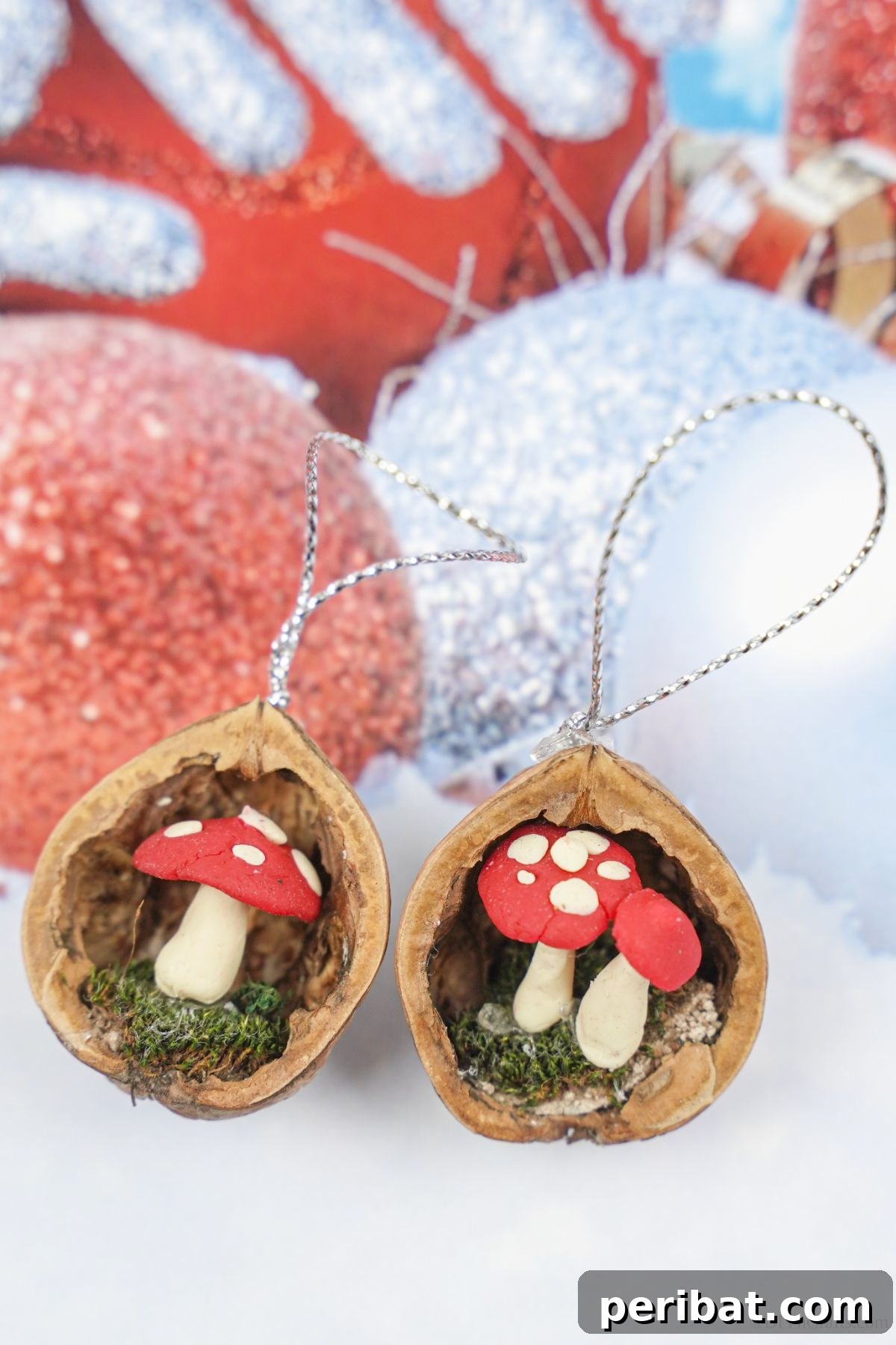 Three Scandinavian-style walnut shell mushroom ornaments are artfully arranged on holiday-themed paper, showcasing their delicate craftsmanship and charming simplicity for festive decoration.