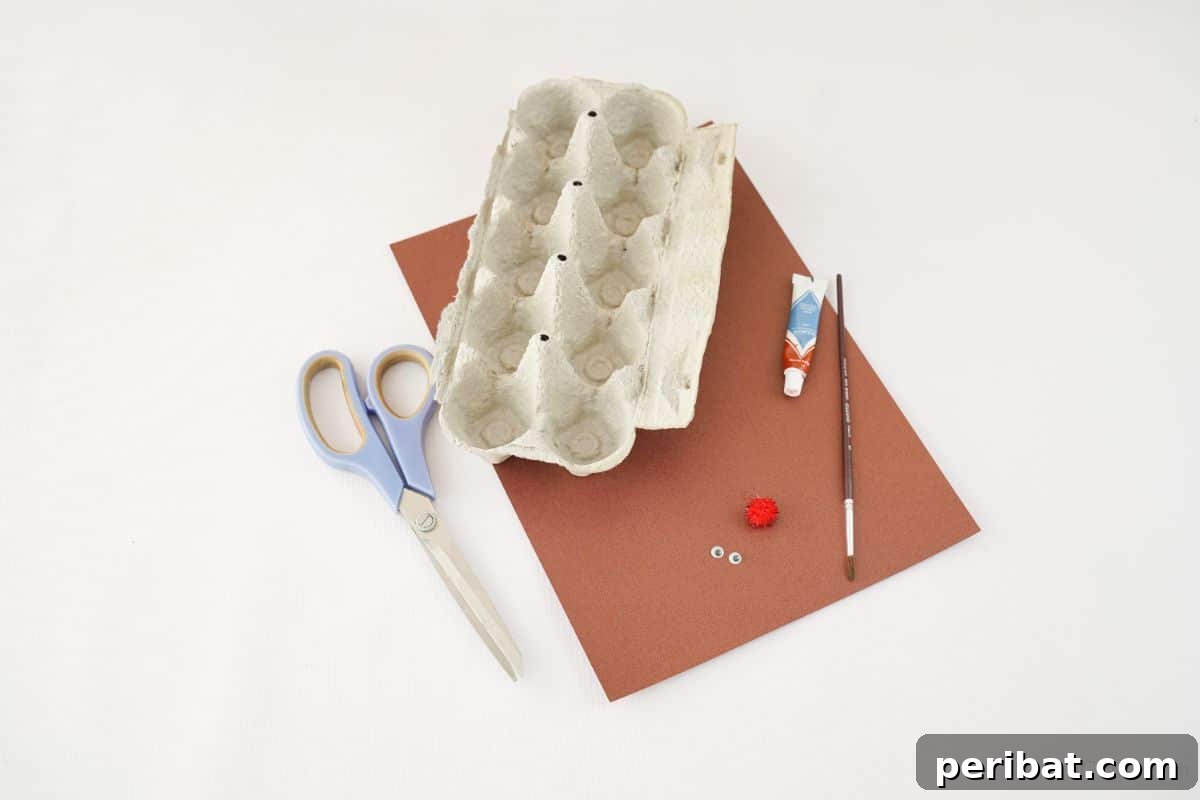 Scissors lying on a table next to brown paper and an egg carton, set up for a fun DIY craft project.