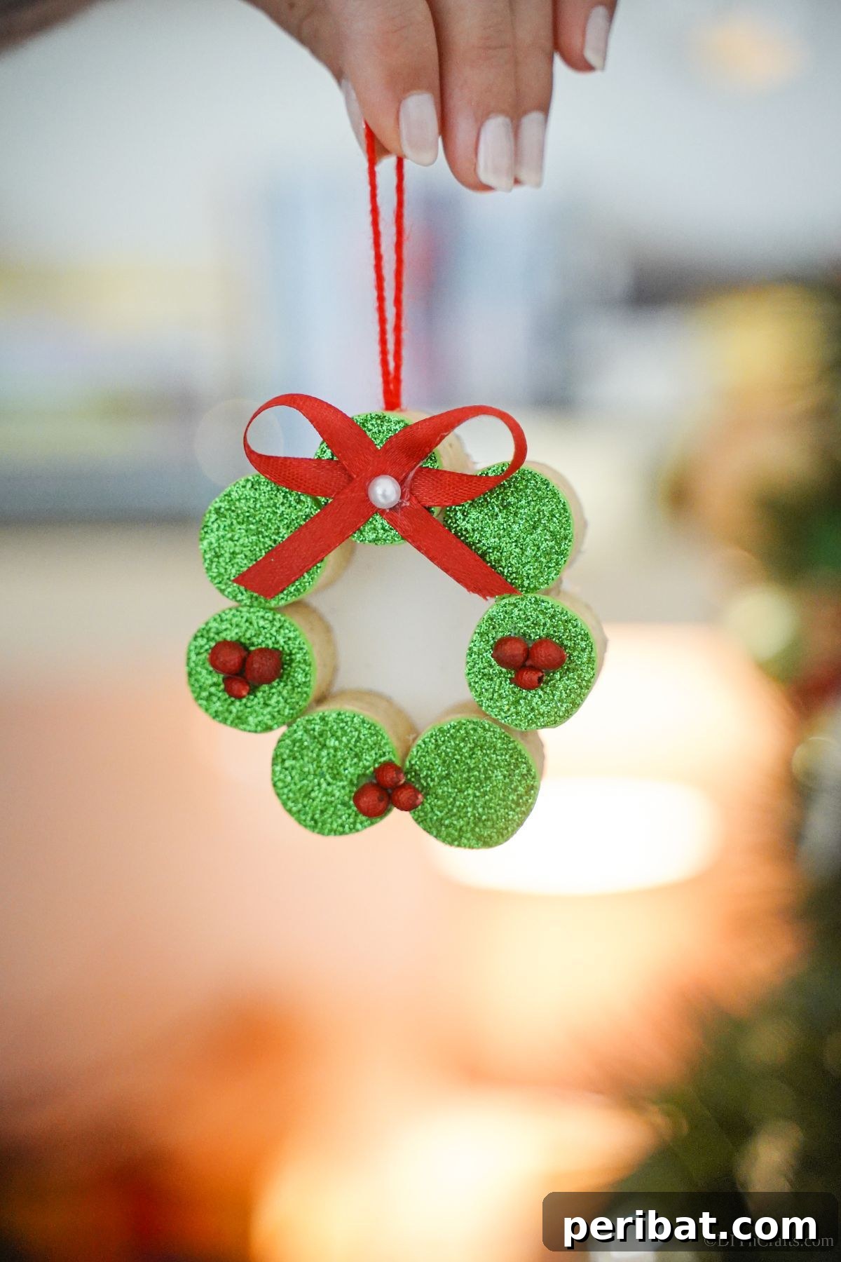 Repurposed Cork Wreath Charm 13 Hand holding a finished green wine cork wreath ornament, ready for display