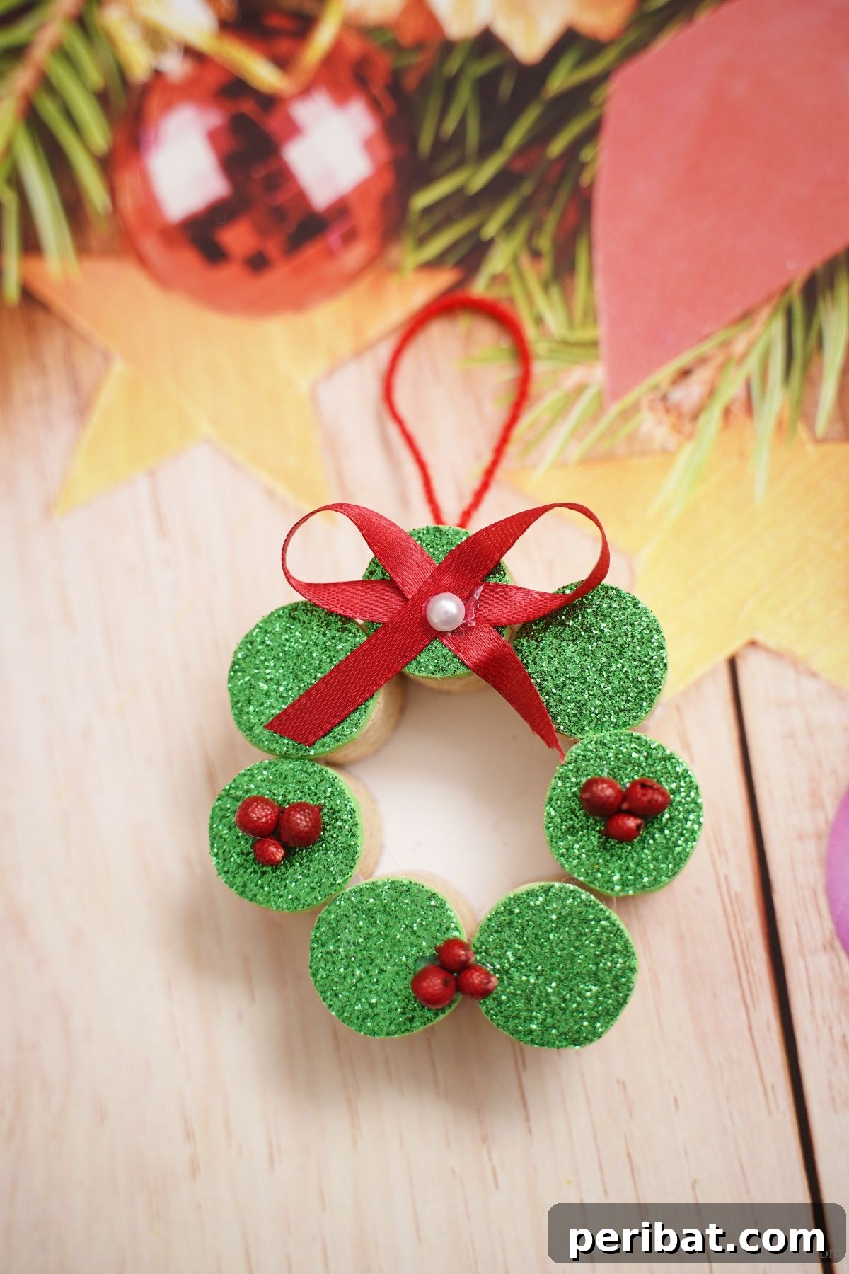 Repurposed Cork Wreath Charm 7 Wine cork wreath ornament laying on holiday themed paper with festive designs