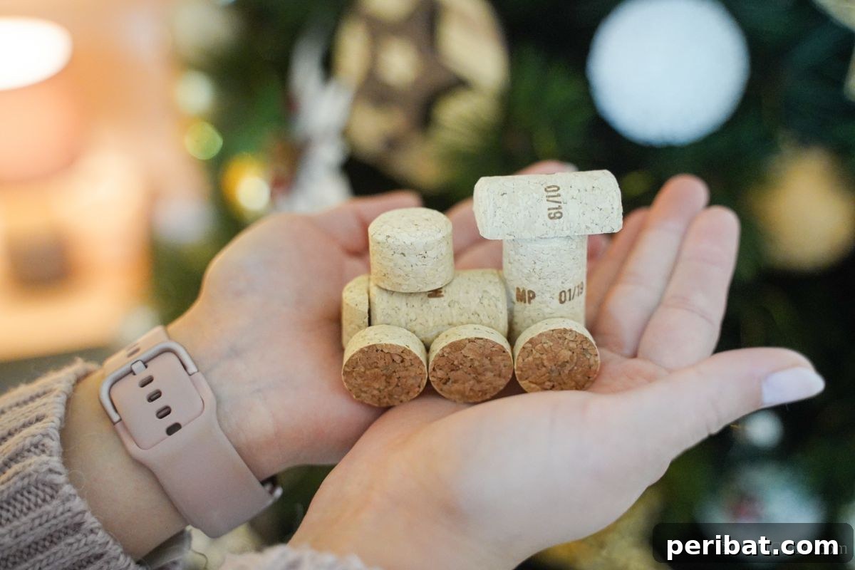 Wine Cork Express Christmas Ornament 16 A beautifully crafted wine cork train ornament held in hands, positioned against the warm glow of a decorated Christmas tree