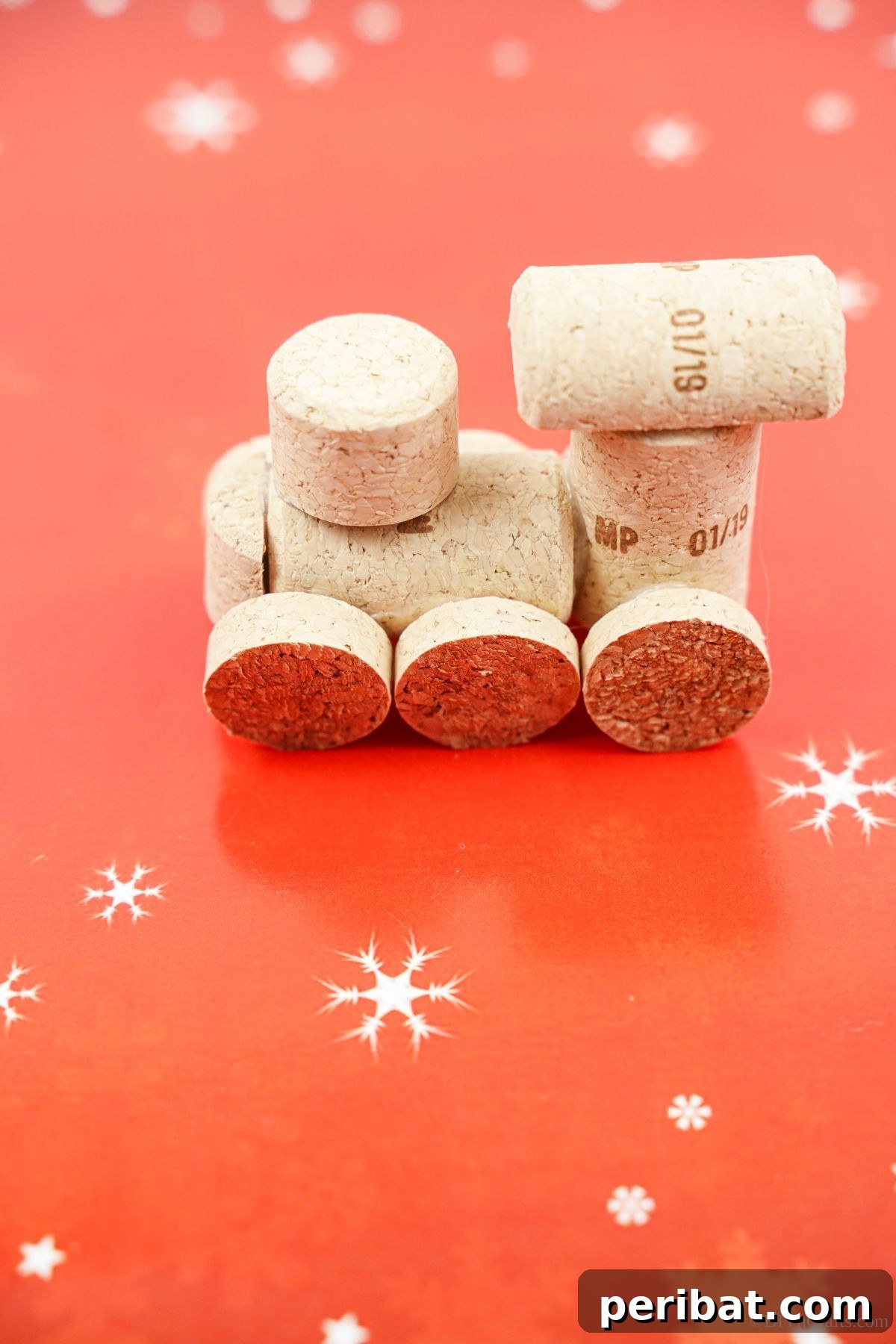 Wine Cork Express Christmas Ornament 17 A rustic wine cork train ornament displayed on a festive red and white patterned paper, ready for the holidays