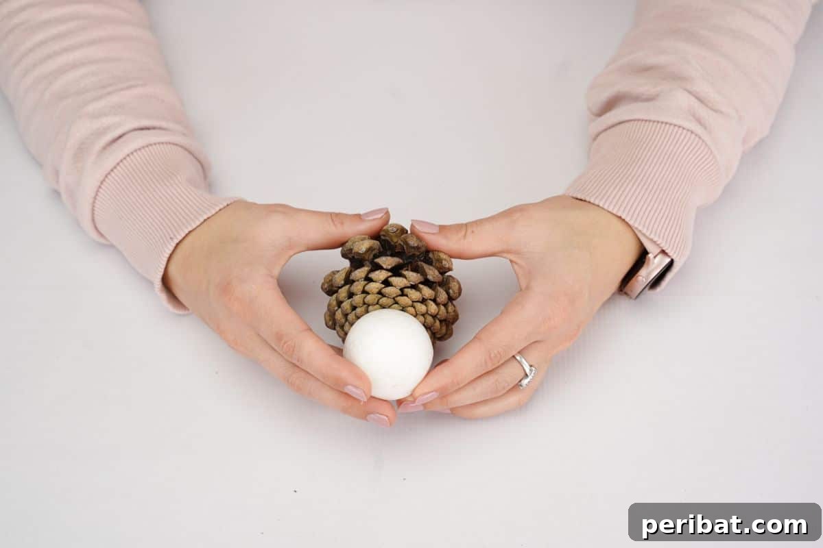 Woodland Pinecone Snowman Charm 11 hand holding pinecone and white ball together