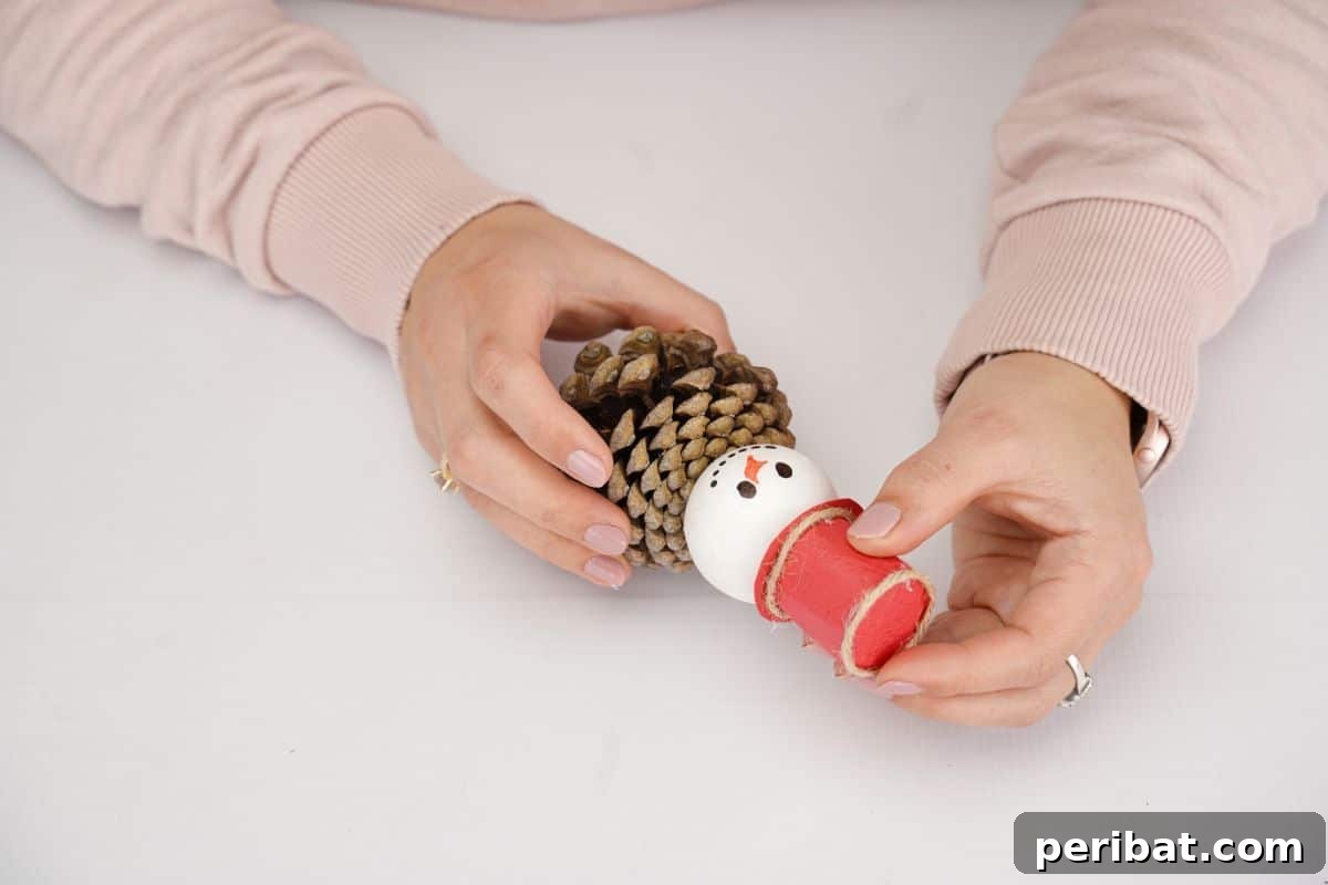 Woodland Pinecone Snowman Charm 13 red hat being glued on snowman ornament head