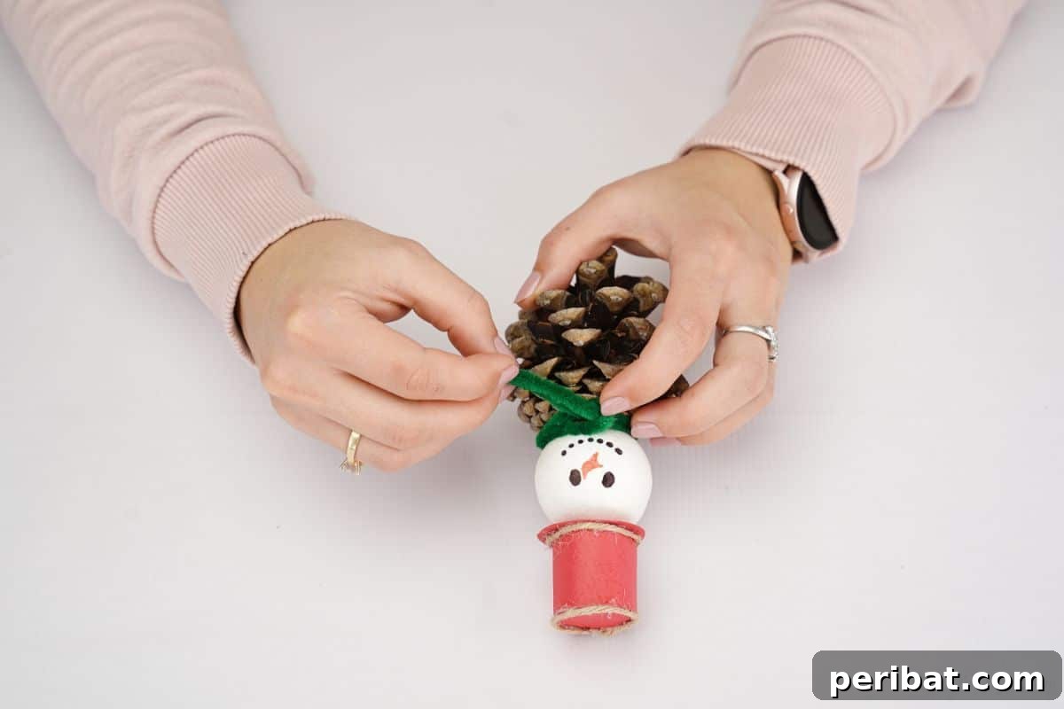 Woodland Pinecone Snowman Charm 14 green pipe cleaner being wrapped around neck of snowman