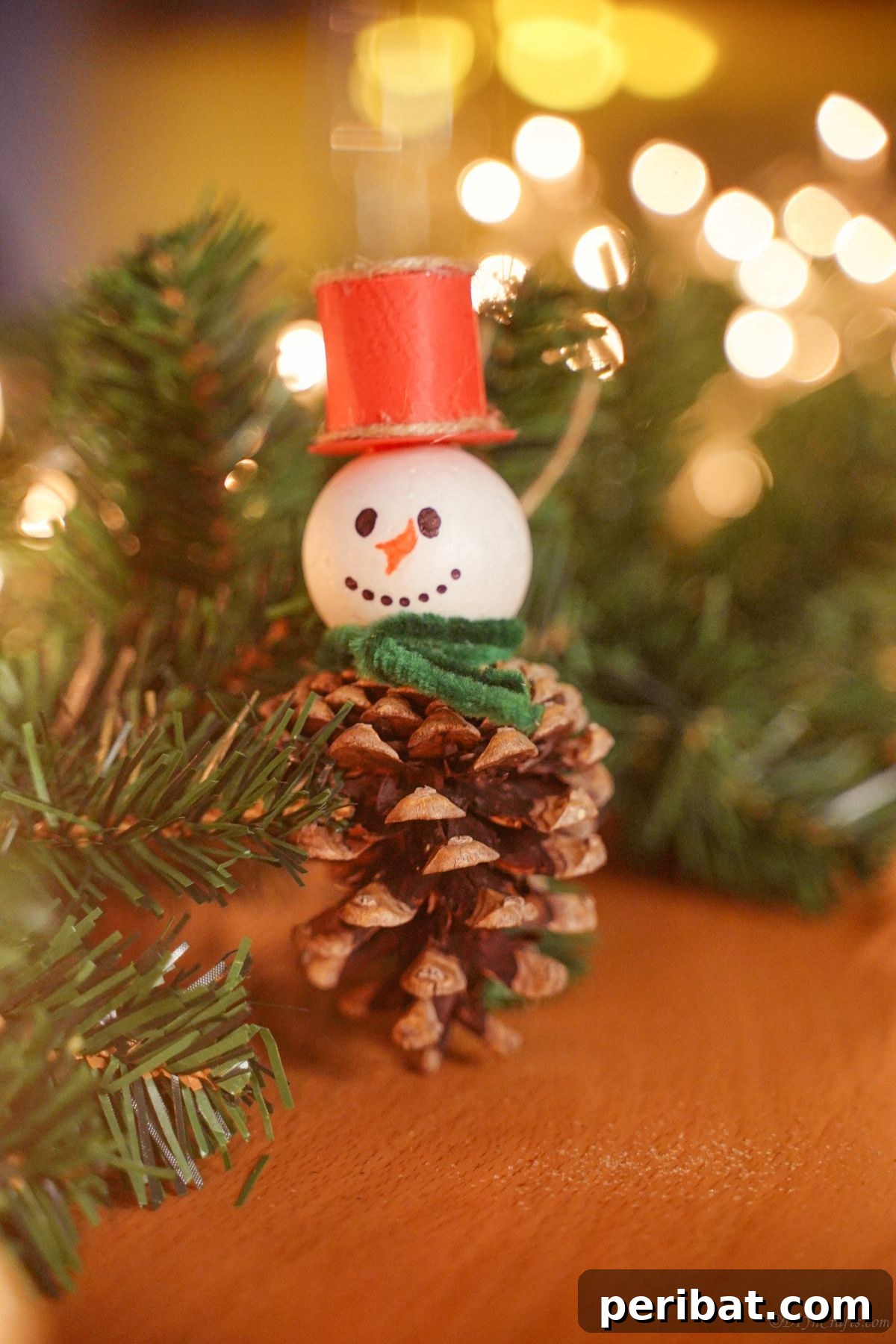 Woodland Pinecone Snowman Charm 3 pinecone ornament on table with greenery