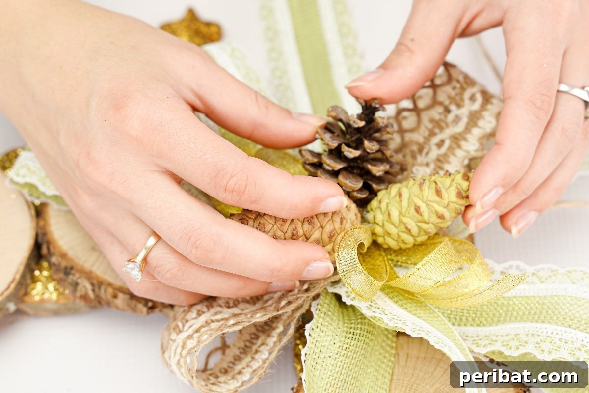 Natural Branch Slice Wreath Adorned with Pinecones 18 Pinecone being held against the bows on the wreath, ready to be glued