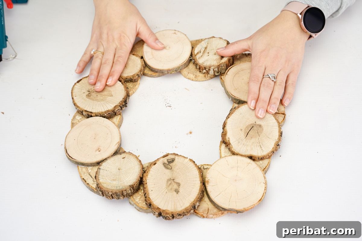 Natural Branch Slice Wreath Adorned with Pinecones 11 Wood slices being glued on top of more wood slices