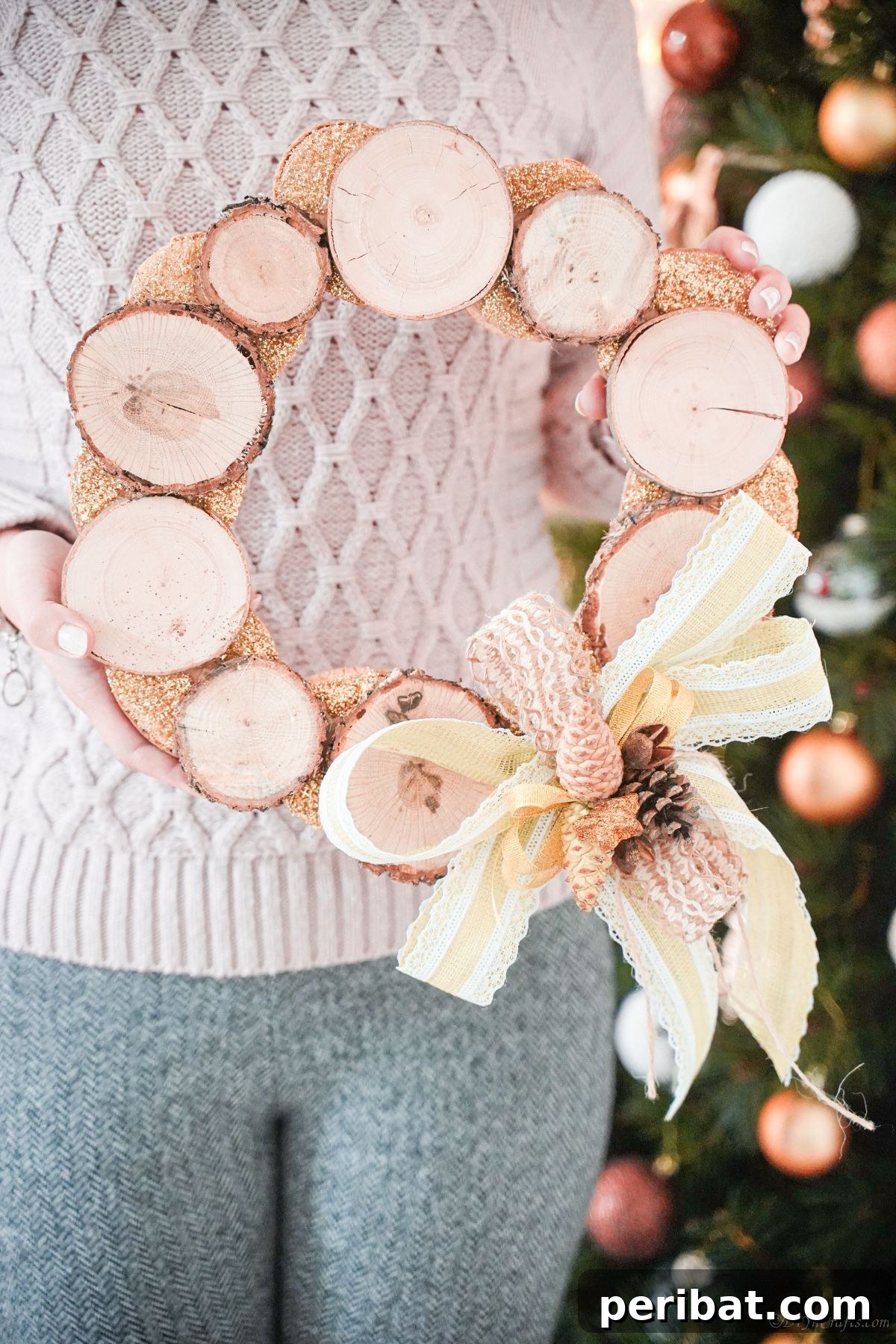 Natural Branch Slice Wreath Adorned with Pinecones 22 Wood slice wreath held by a woman in a blue sweater