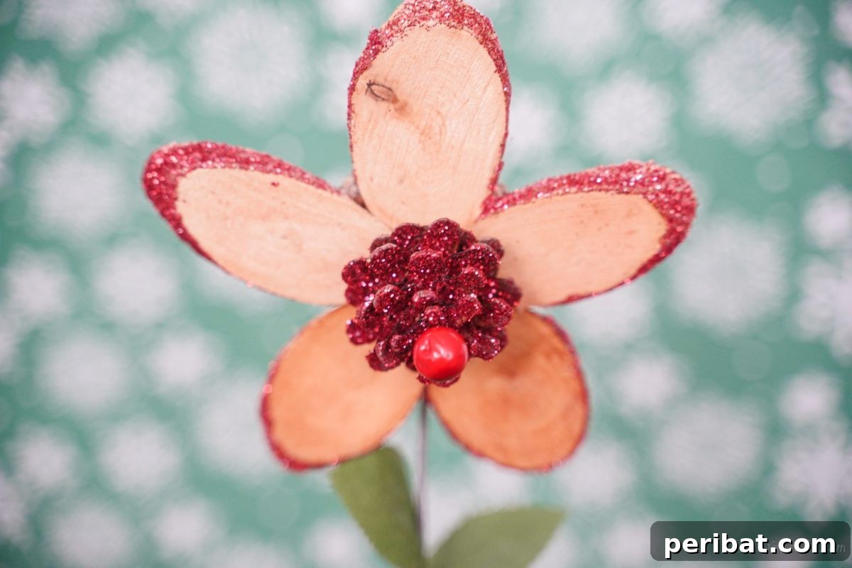 close up image of wood slice flower in front of green and white background