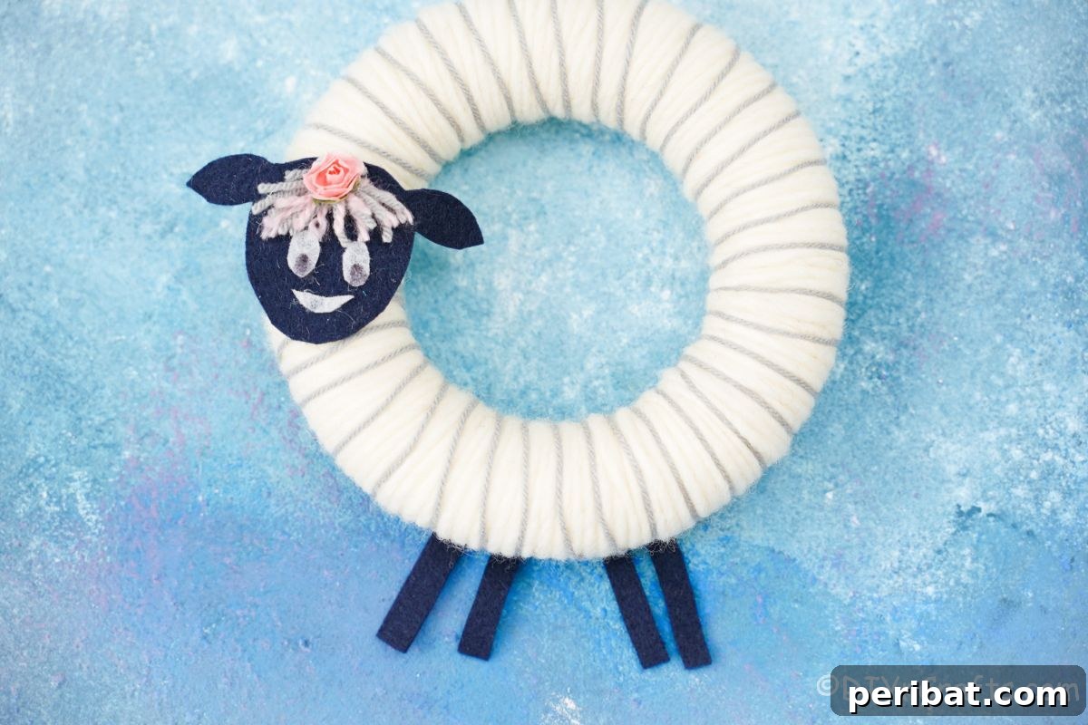 Whimsical Woolly Lamb Easter Wreath 3 Fluffy white yarn sheep wreath with felt face and ears, set against a vibrant blue background, celebrating Easter.