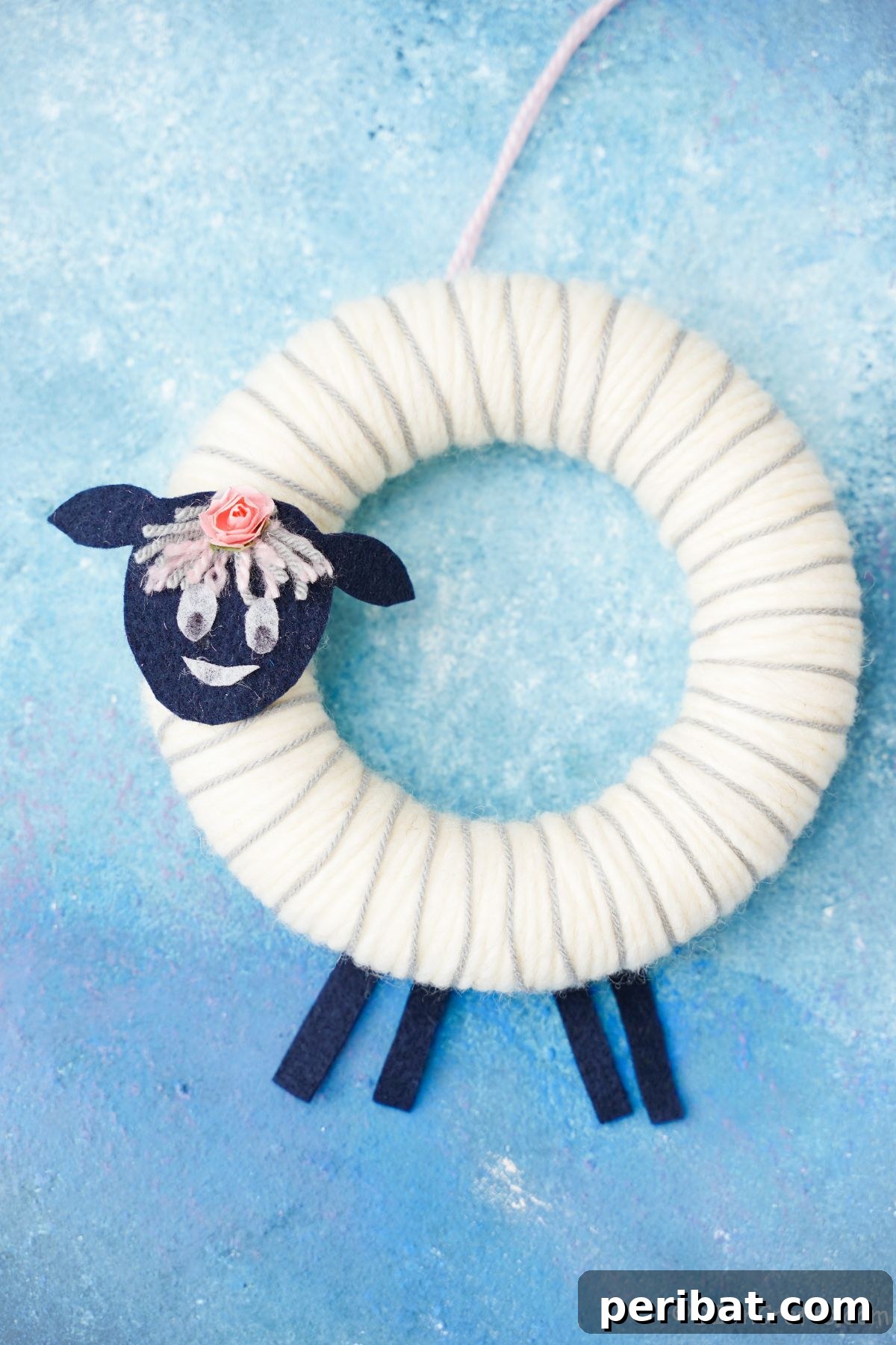 Whimsical Woolly Lamb Easter Wreath 19 A charming white yarn sheep wreath against a soothing blue background, perfect for spring decor and Easter celebrations.