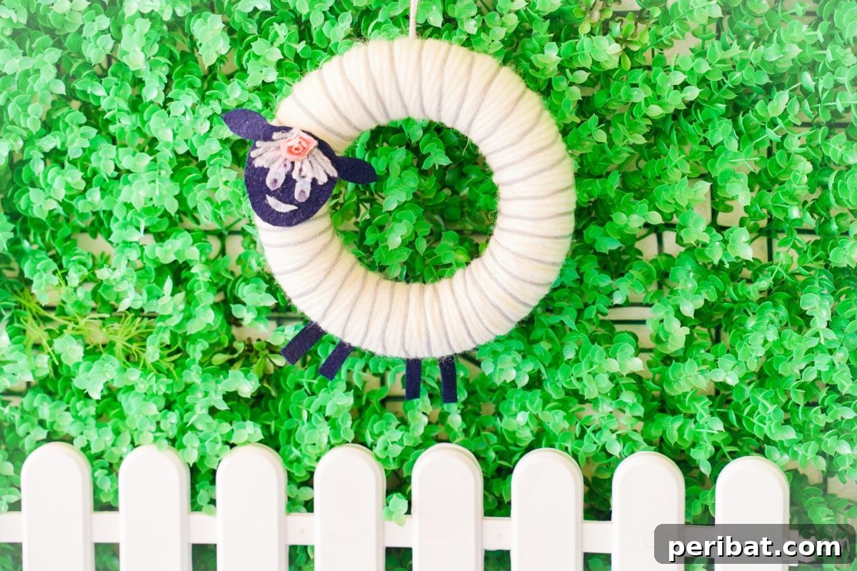 Whimsical Woolly Lamb Easter Wreath 21 An endearing yarn sheep wreath displayed outdoors on lush green grass with a white picket fence, embodying the joyous spirit of springtime and Easter.