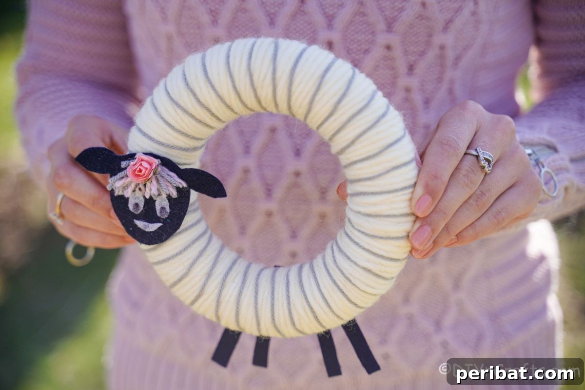 Whimsical Woolly Lamb Easter Wreath 6 A crafter proudly holding up a finished yarn sheep wreath, demonstrating its charm and ideal size for display.
