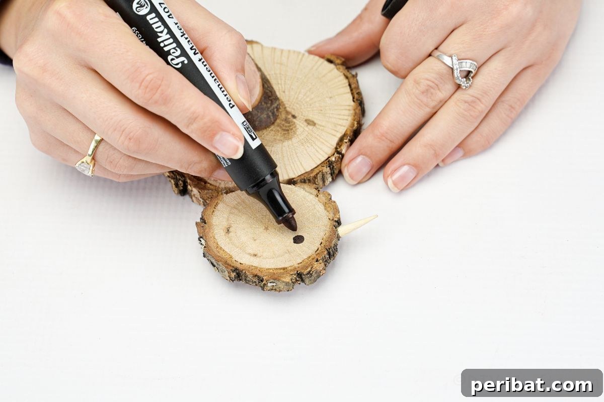 black marker drawing an eye on the wood slice chick