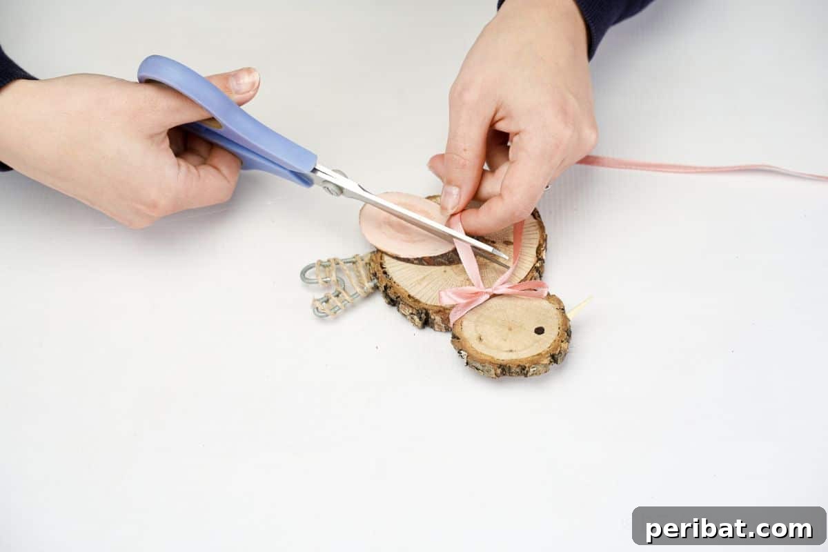 hand holding blue scissors cutting pink ribbon for the chicken's bow