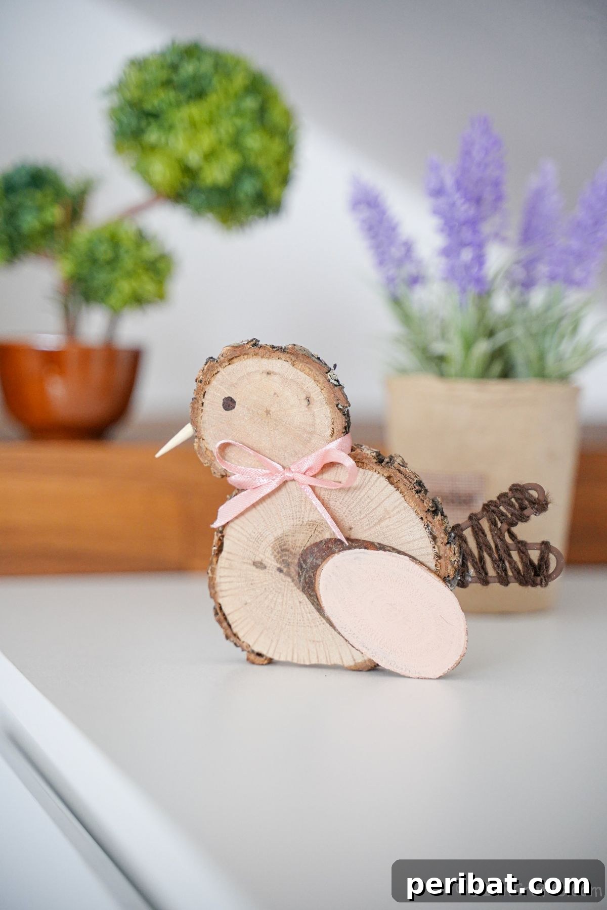 wood slice chicken with a delicate pink bow on a white table