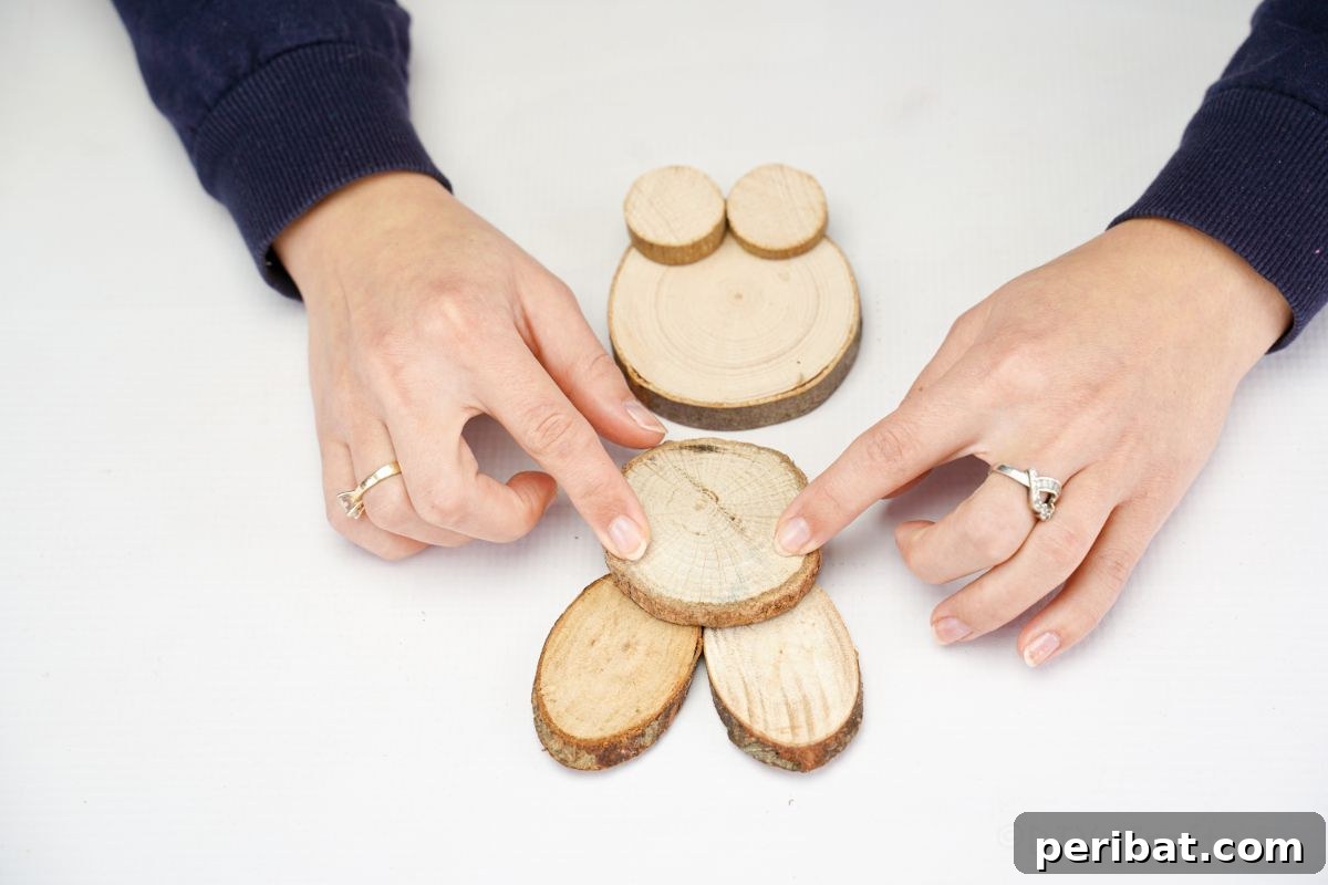 hands gluing wood slices together to form bunny head