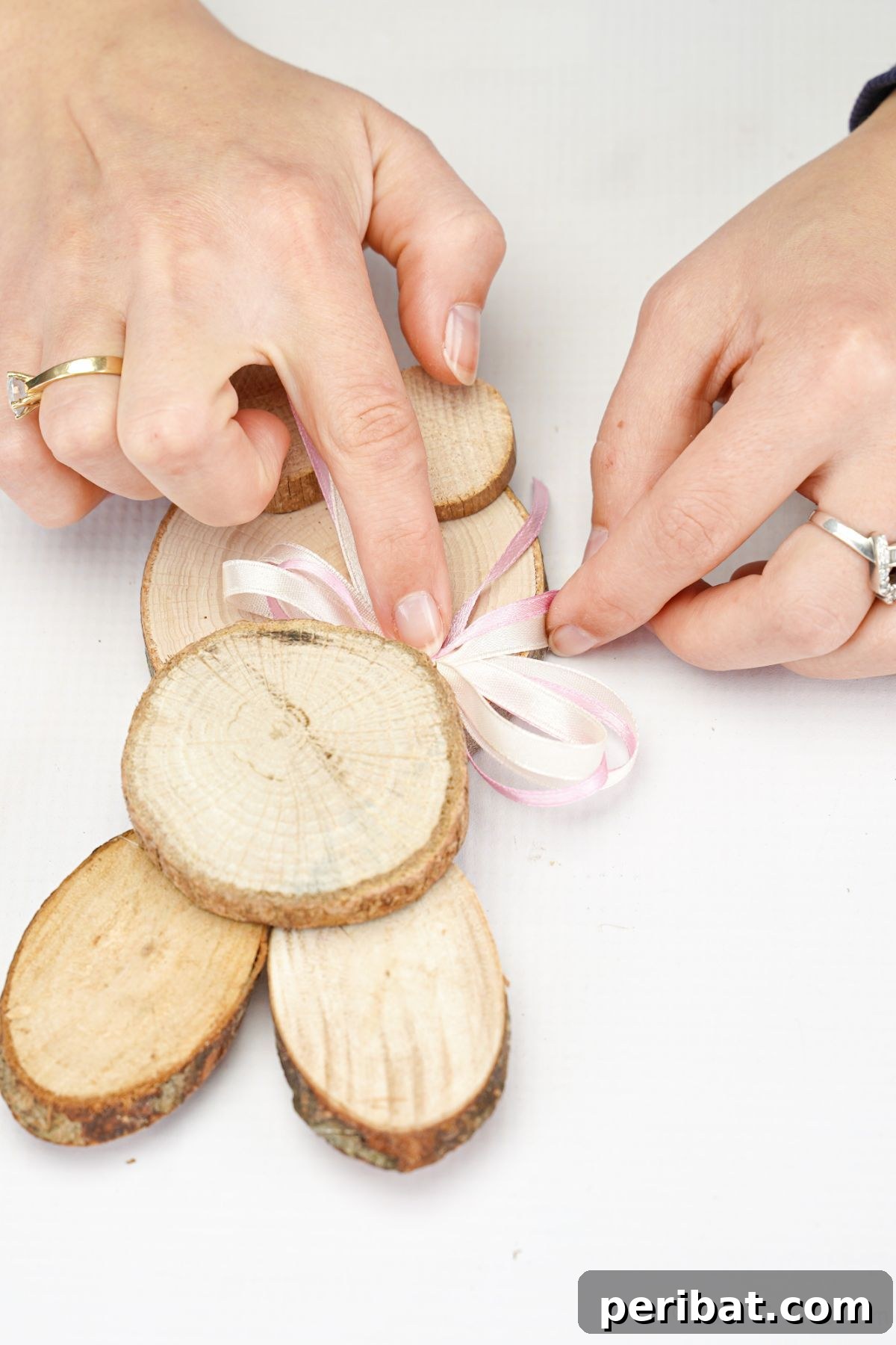 hand gluing ribbon onto wood slice bunny