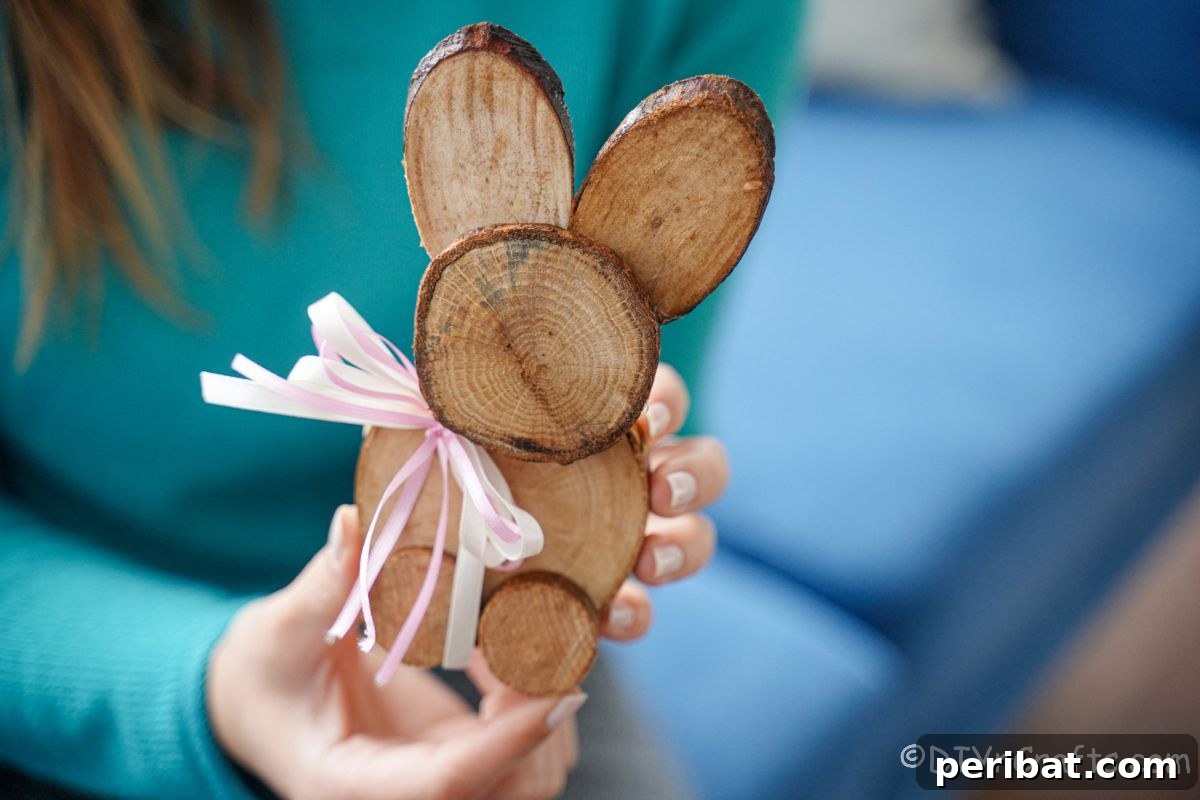 hand holding small wood slice bunny