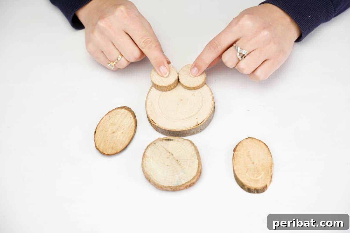 hand putting small wood slices on bottom of wood slice bunny belly