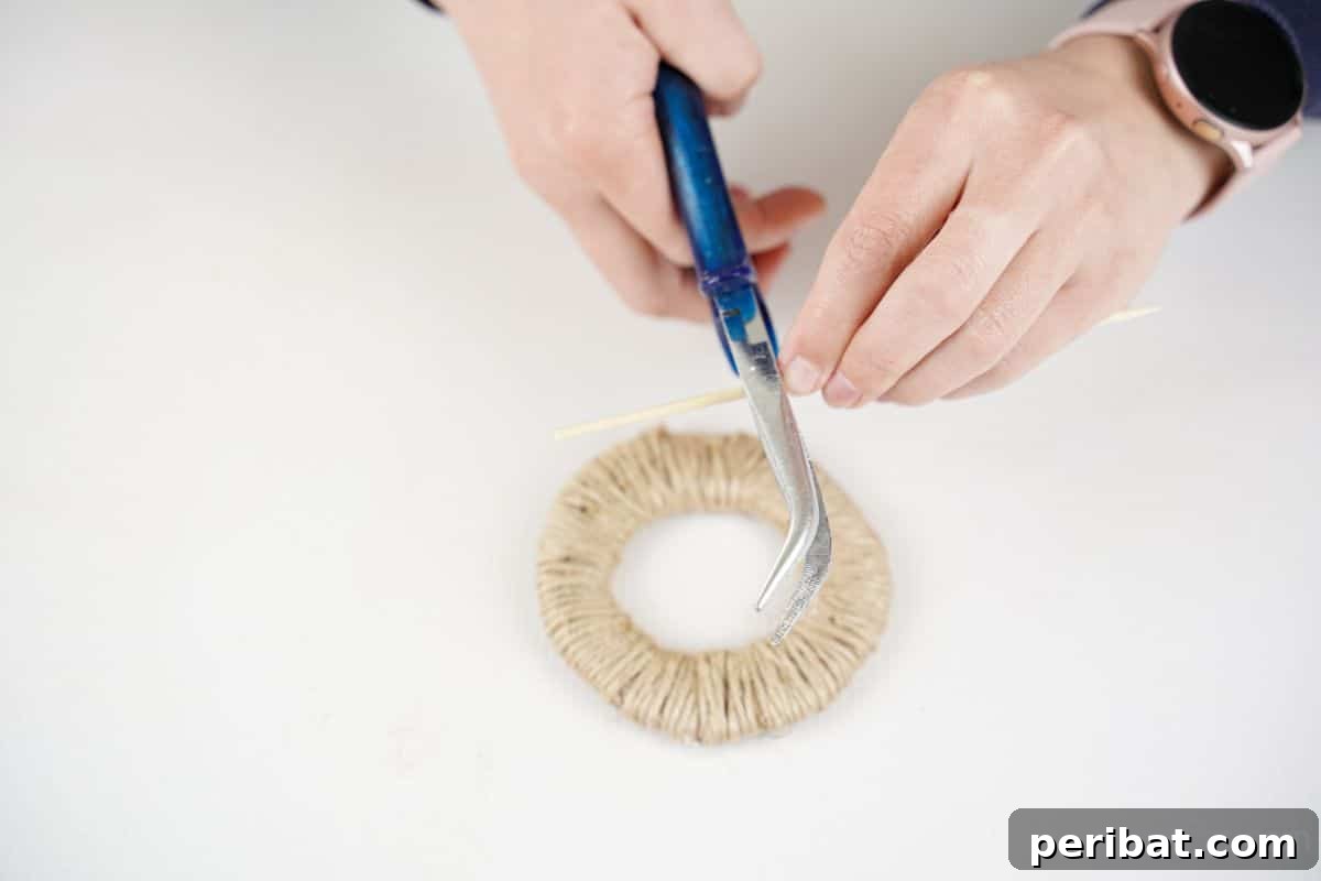 Scissors trimming a dowel rod over a twine-wrapped wheel, preparing spokes for assembly.