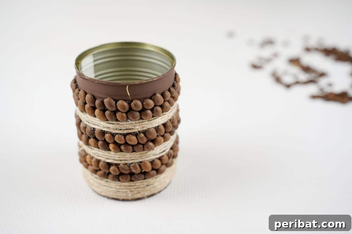 Tin can completely covered in alternating stripes of twine and coffee beans, showcasing the rustic pattern.