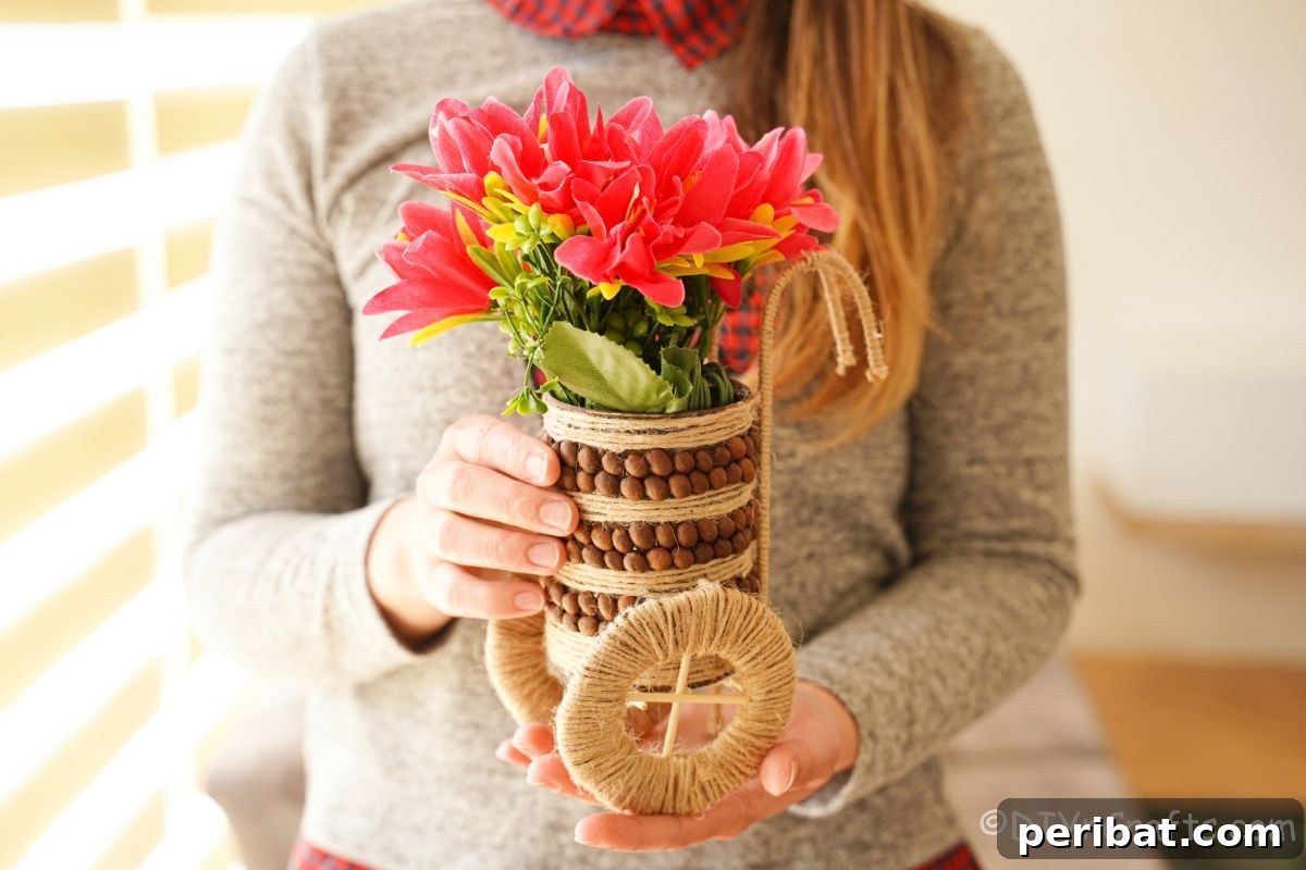 Woman proudly holding a rustic upcycled tin can vase filled with vibrant pink flowers.