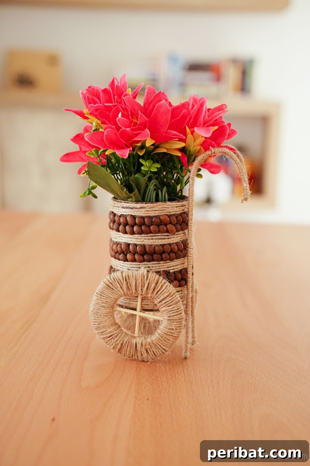 Decorated tin can vase wrapped in twine, sitting on a rustic wooden table, awaiting embellishment.