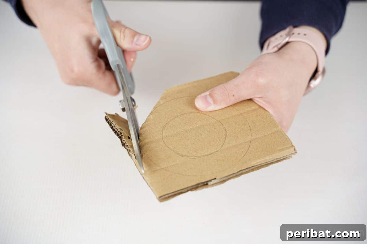 Scissors meticulously cutting a cardboard circle, destined to become a decorative wheel.
