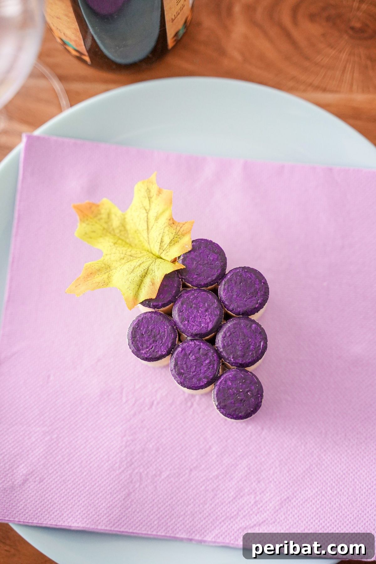 Painted wine cork grape cluster sitting on a white plate, showcasing its finished look.
