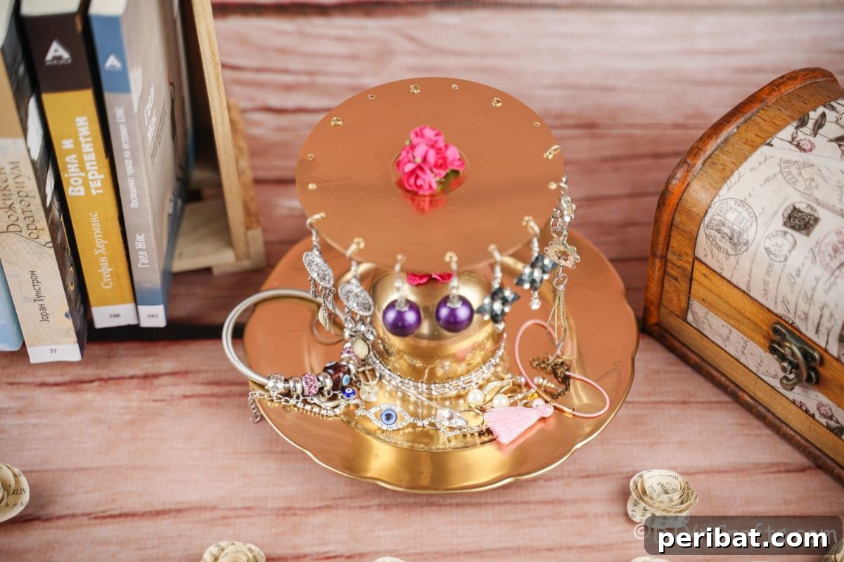 2-tier gold jewelry stand on wood table by small box