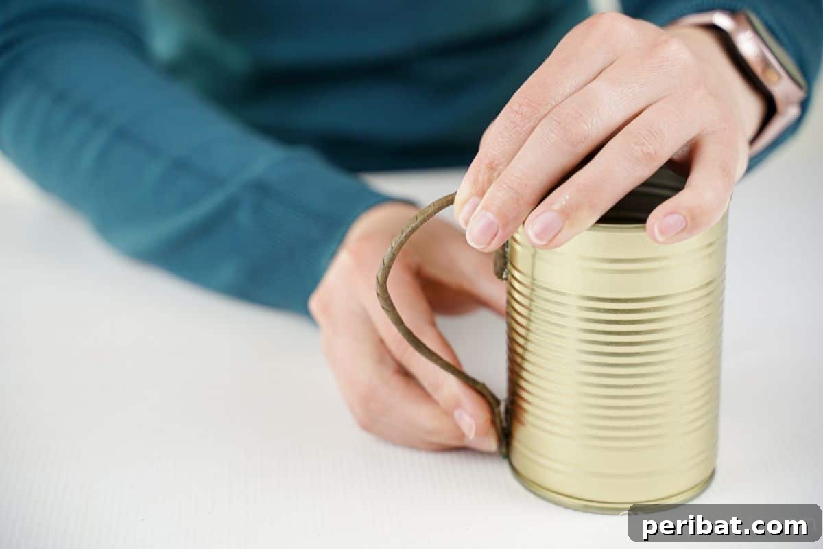 Rustic Coffee Motif Tin Watering Can 13 Hand securely gluing the newly shaped handle onto the side of a tin can