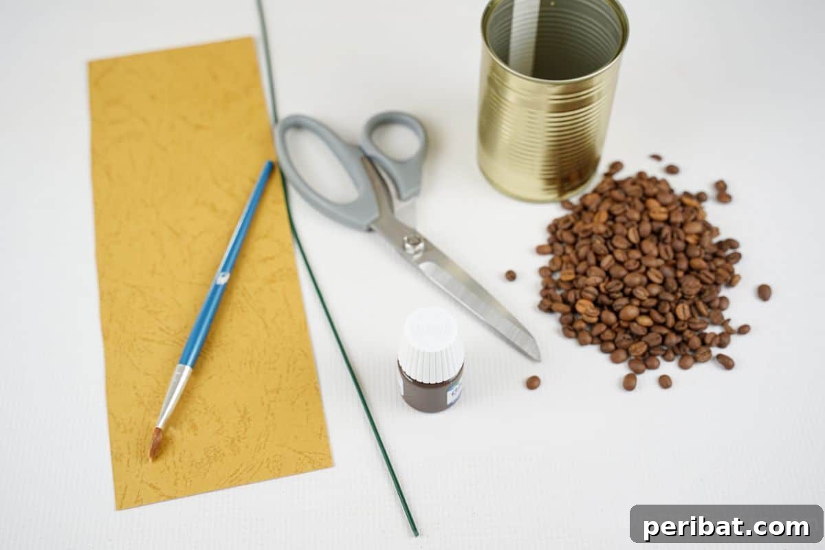 Rustic Coffee Motif Tin Watering Can 9 Crafting supplies laid out: yellow paper, paintbrush, coffee beans, tin can, and floral wire on a white table