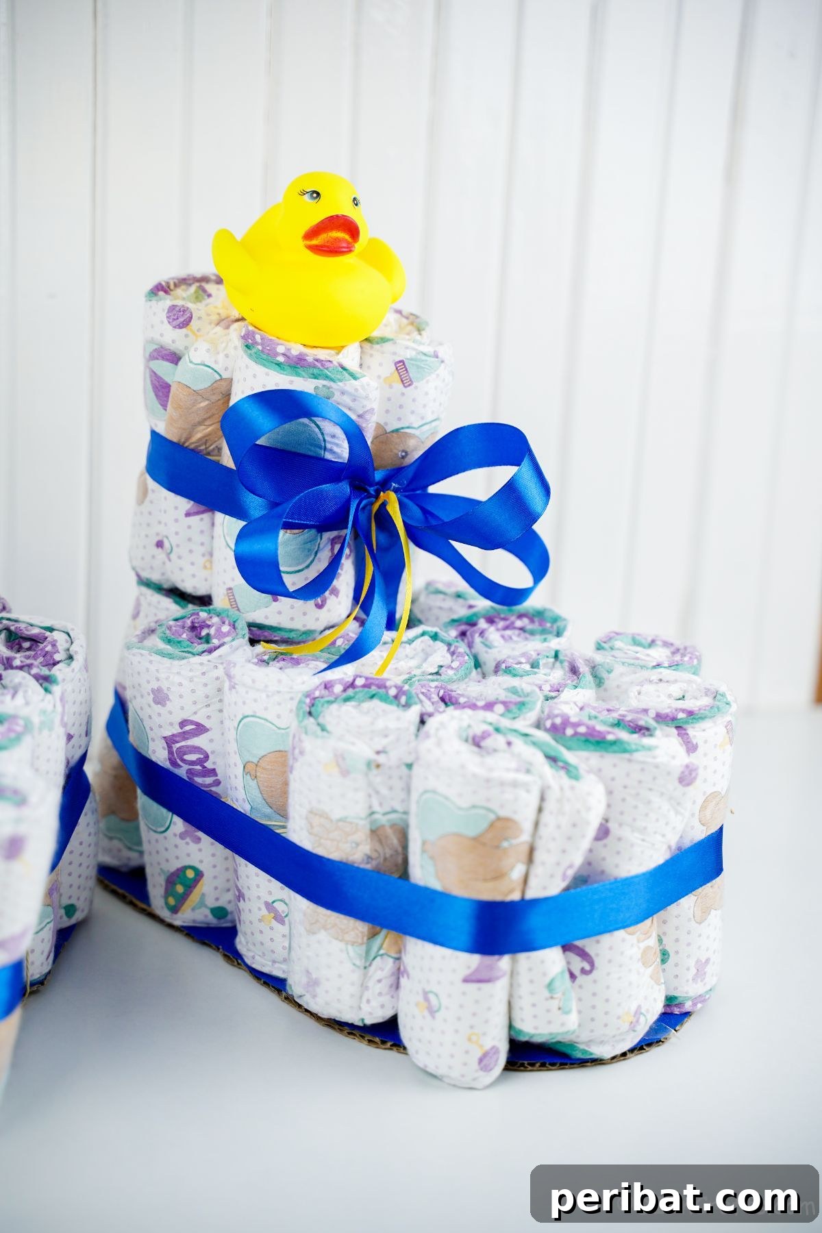 Sweet Steps Diaper Cake Delight 21 white wall behind baby bootie diaper cake