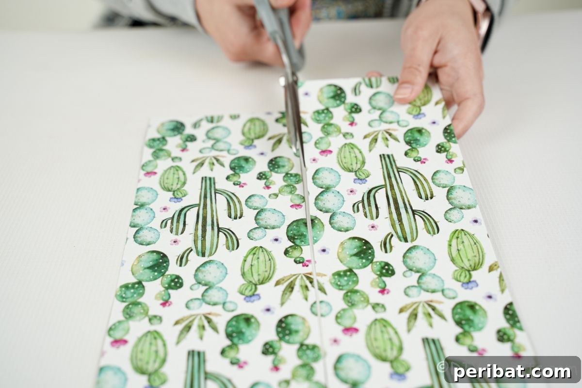 Vibrant Upcycled Tin Can Wind Socks 10 A person carefully cutting a piece of cactus-patterned scrapbook paper with grey-handled scissors to size for the tin can.
