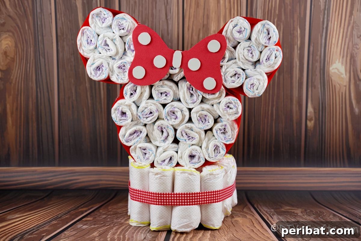 The fully assembled Disney red and white Minnie Mouse head diaper cake proudly displayed against a rustic wood wall.
