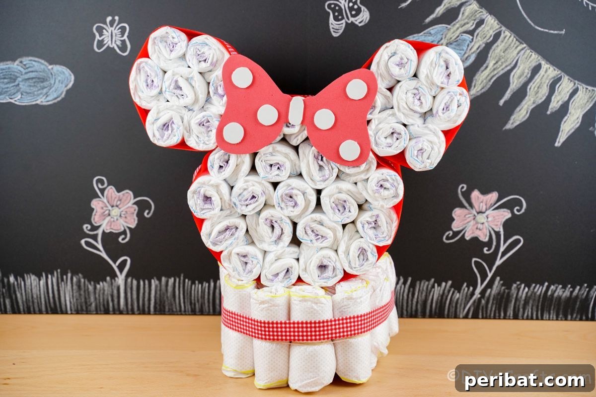 Minnie Mouse diaper cake displayed against a charming chalkboard wall, highlighting its decorative appeal.