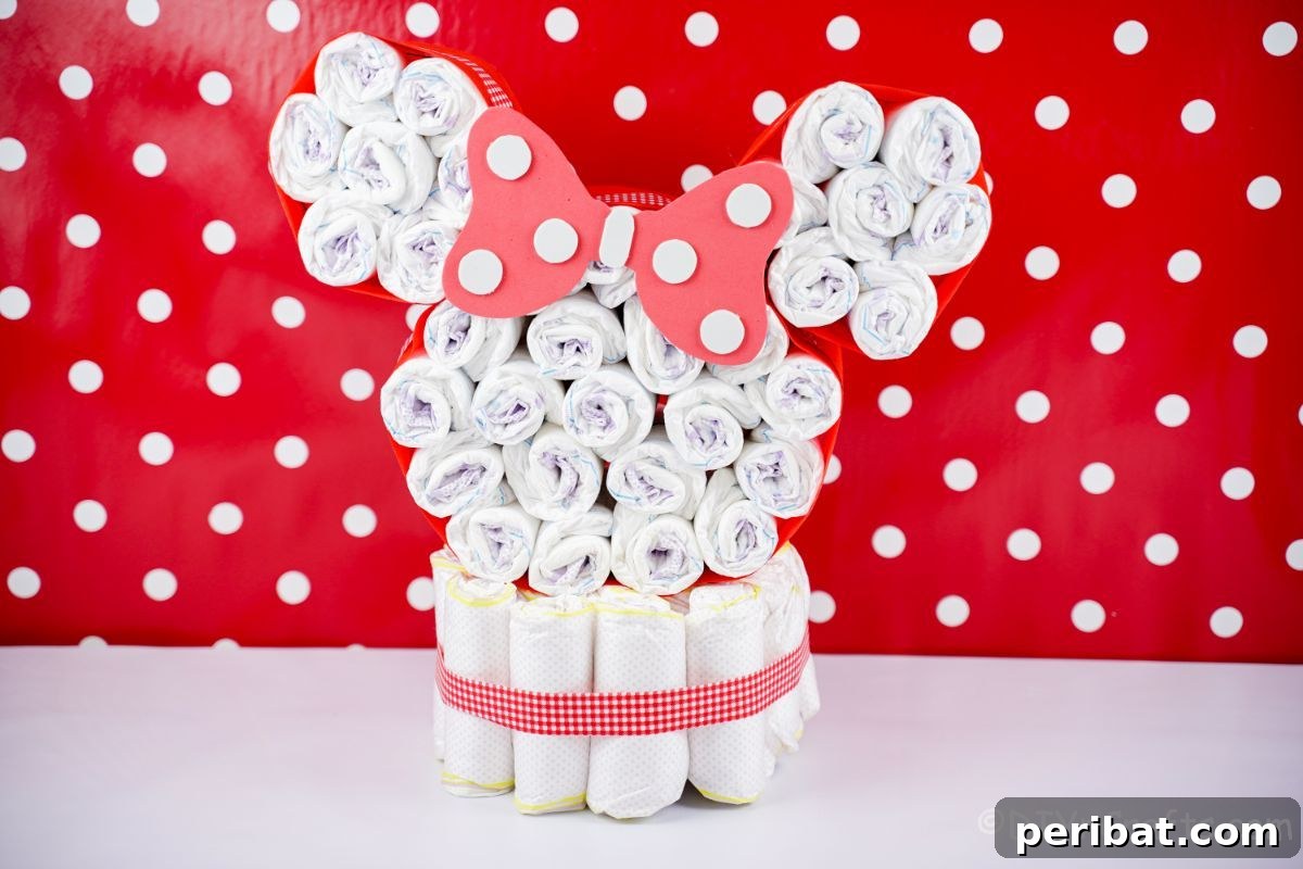 Close-up of the Minnie Mouse head of a diaper cake, set against a fun red and white polka dot wall, emphasizing detail.