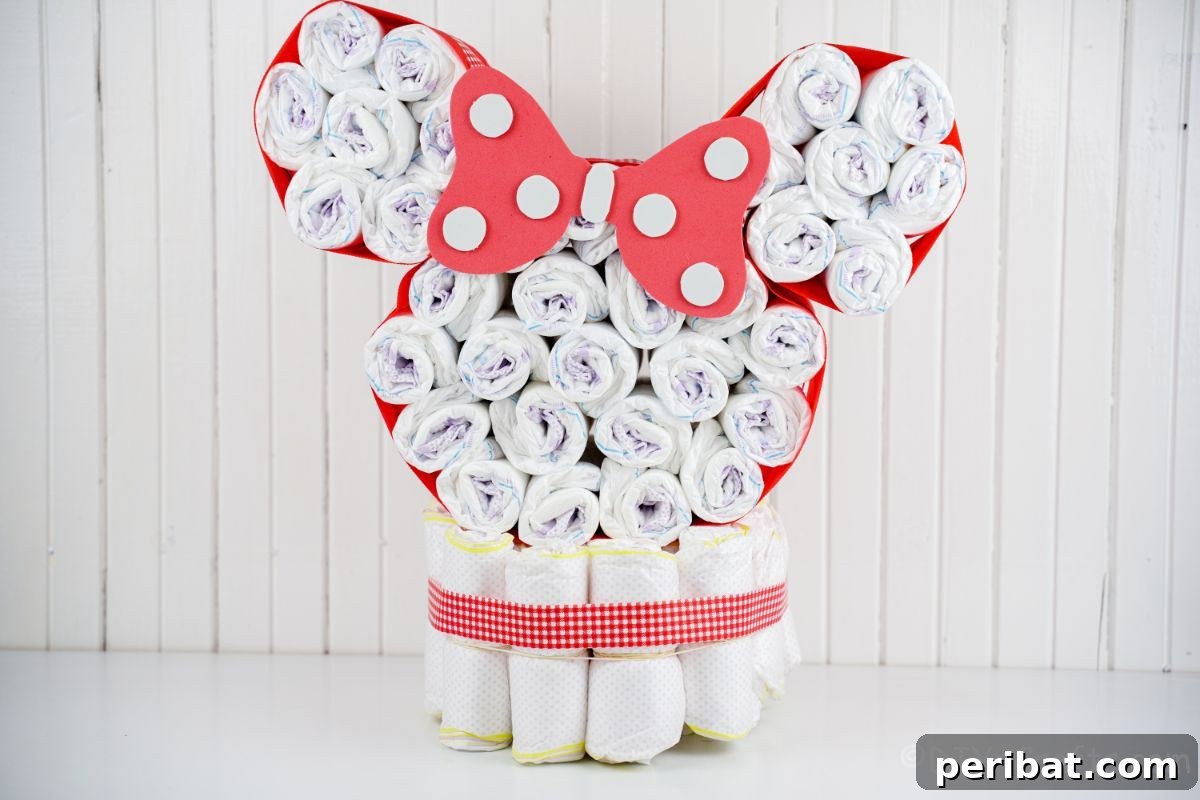 Minnie Mouse diaper cake positioned against a white paneled wall, showcasing its classic Disney aesthetic.