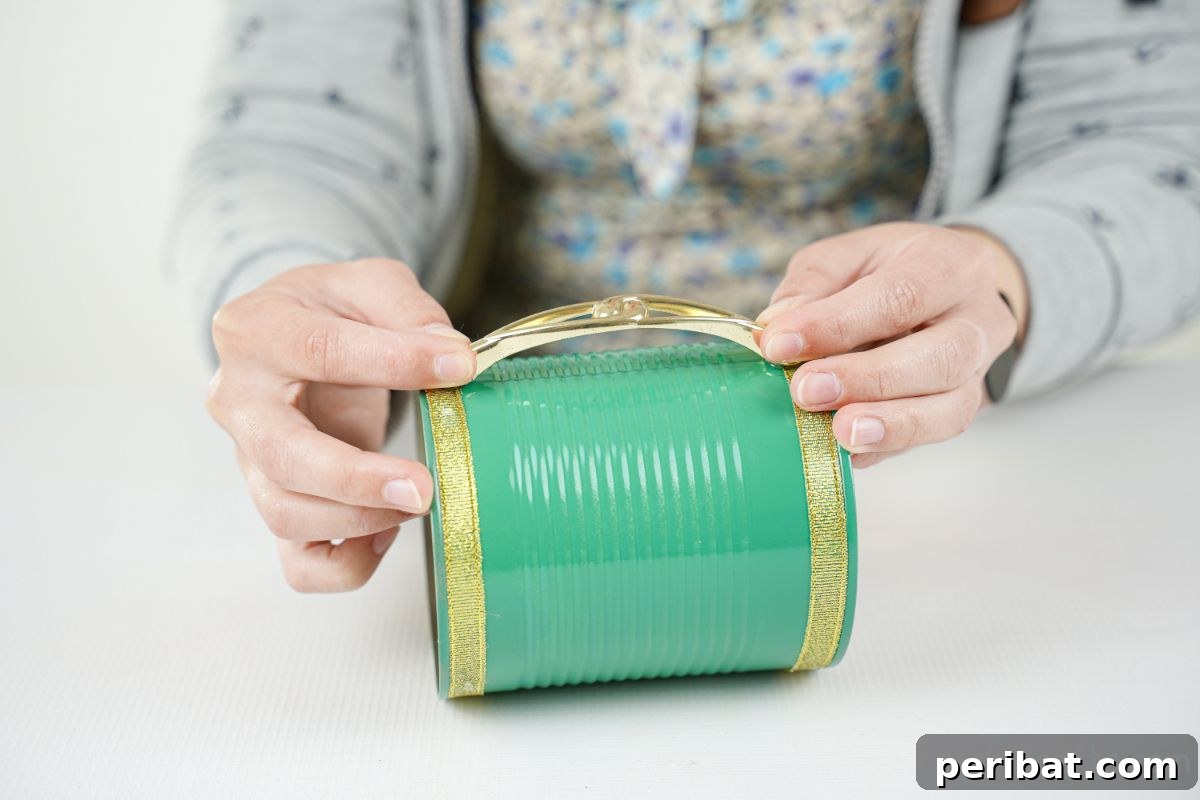 green tin can on table with gold handle being glued to the side of can