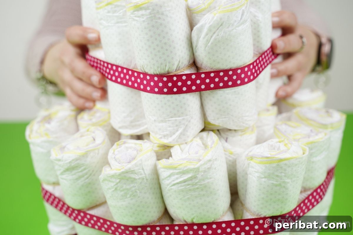 Create a Magical Unicorn Diaper Cake 13 Sitting a small bundle of diapers on top of a larger one to create a two-tiered diaper cake