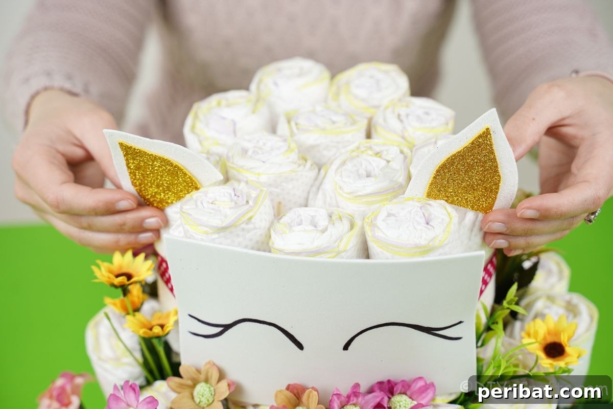 Create a Magical Unicorn Diaper Cake 18 Hand adding ears to both sides of the unicorn diaper cake, positioned above the face