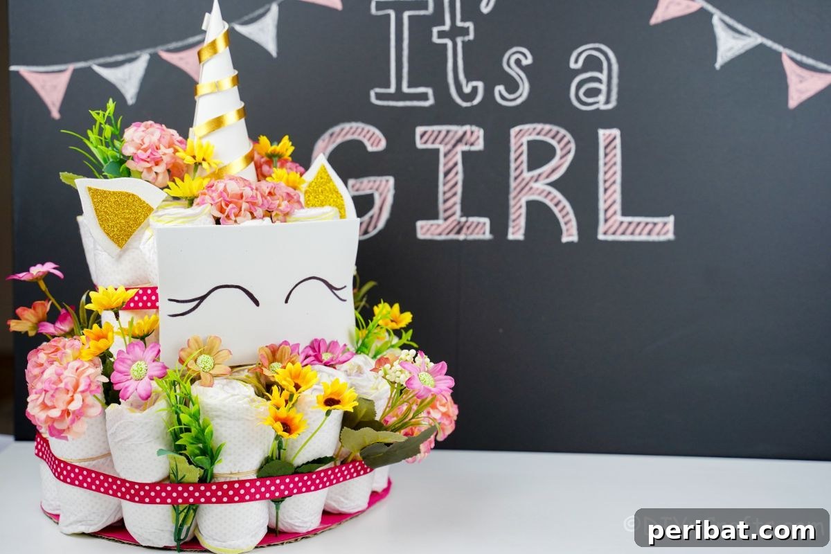 Create a Magical Unicorn Diaper Cake 3 Unicorn diaper cake in front of a chalkboard sign that says its a girl